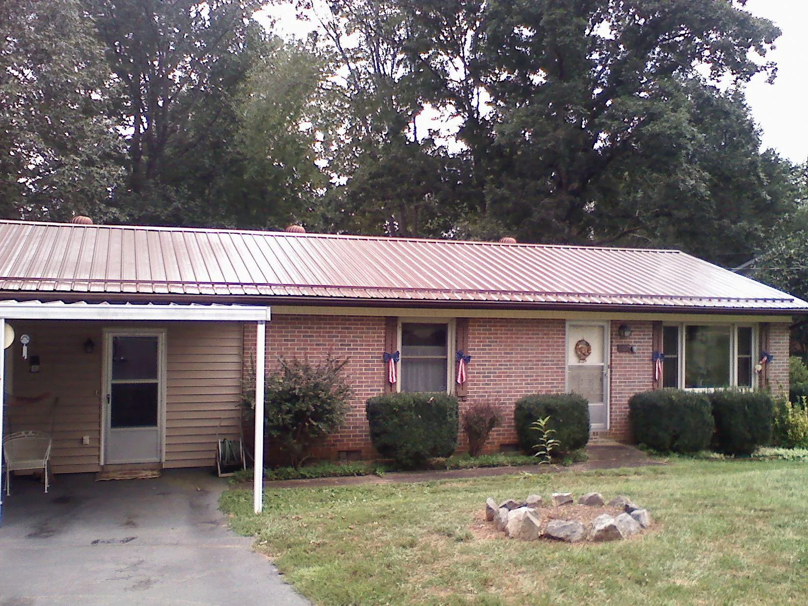 Bronze metal roof and carport on a brick ranch home — Roof Repair work by our crew in Inman