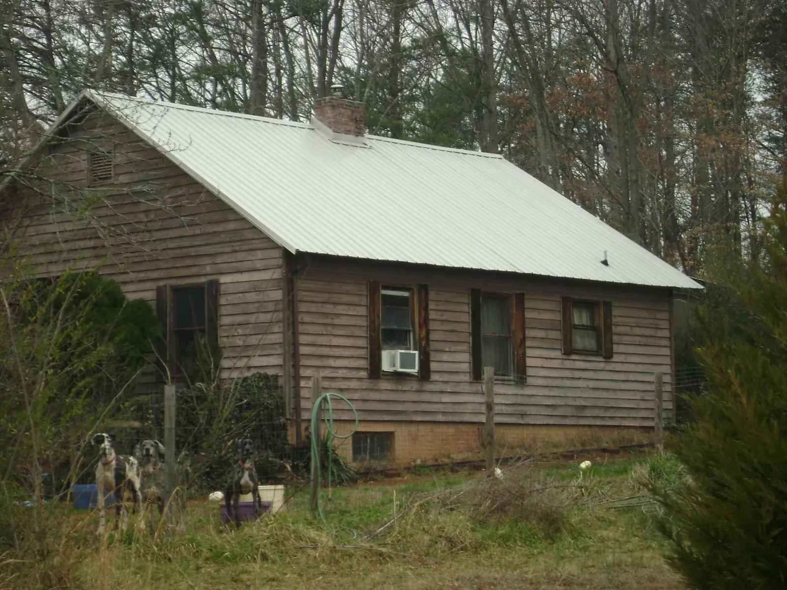 White metal roof on an old wood sided farmhouse, from a Asphalt Shingle Roof Repair job in Inman